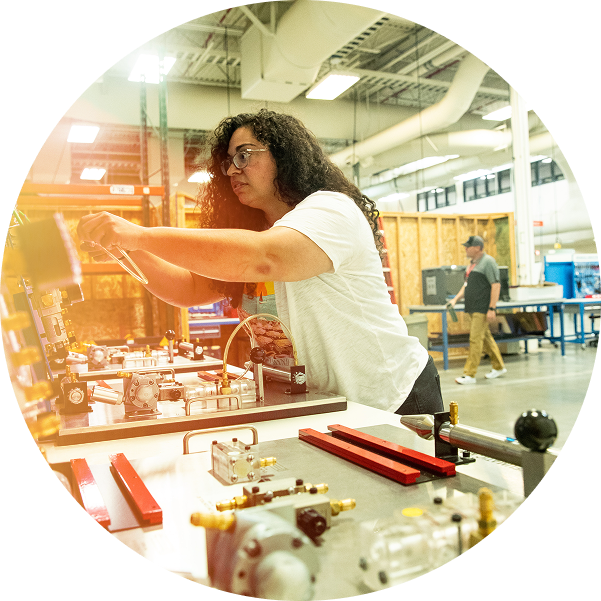 woman in shop working on construction equipment