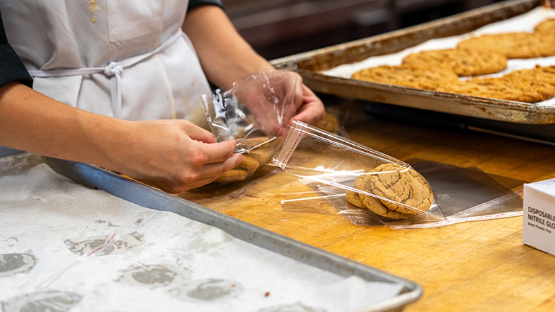 close up of student making cookies and putting them into the wrapper