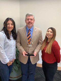(Left) Helen Salcedo, President James R. Taggart, and Priscilla Martinez with the LUPEC award. 