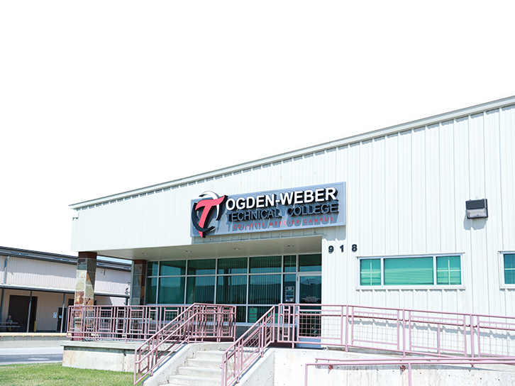 Exterior view of the Ogden-Weber Technical College building entrance with a ramp and staircase, where students can meet with OTECH's job coach and career services team