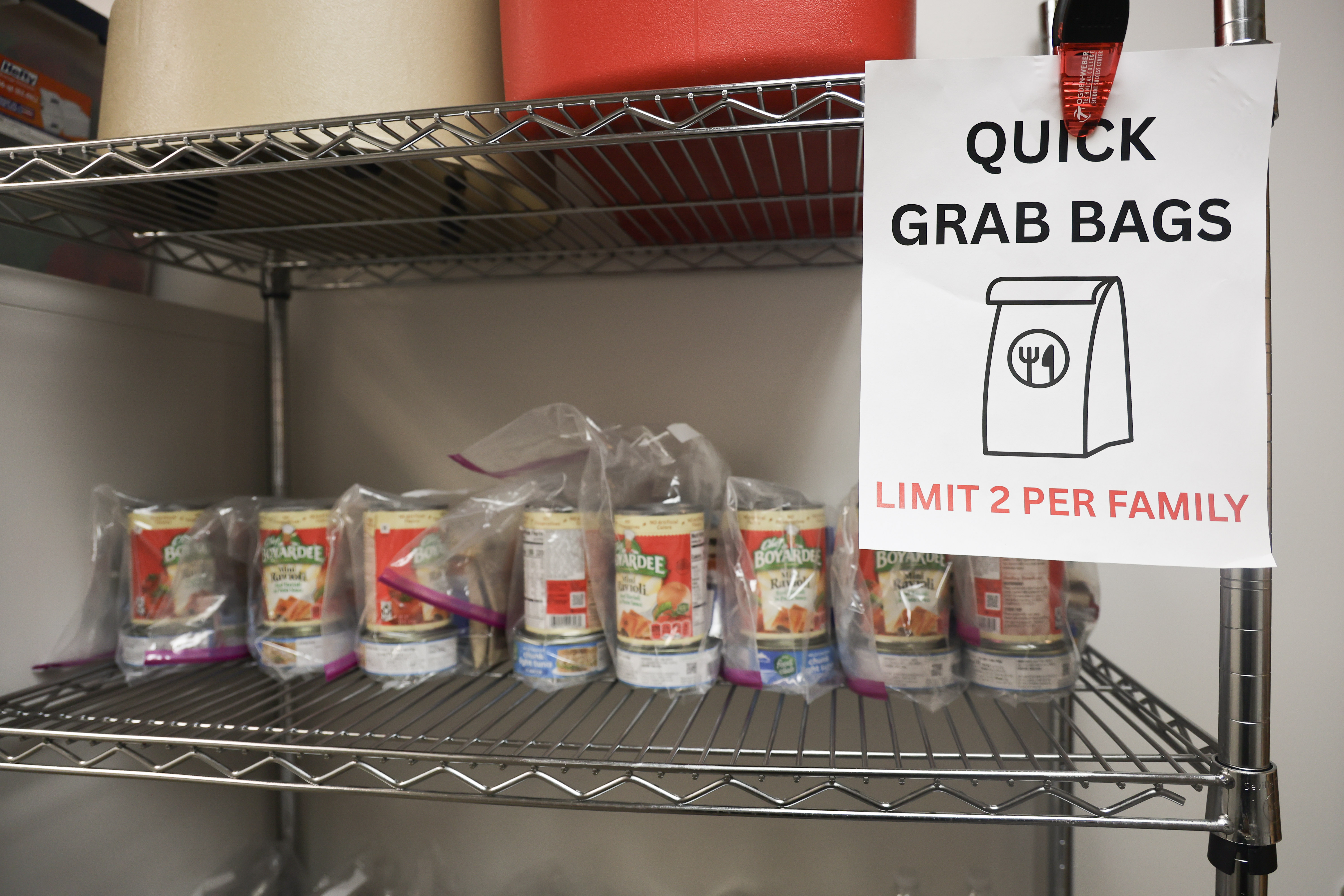 Student Success Center food pantry shelf with canned goods and a Quick Grab Bags sign, limit 2 per family